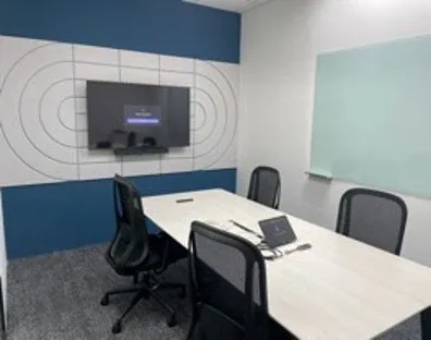 Small meeting room with a wall display, video bar, touch panel and glass whiteboard